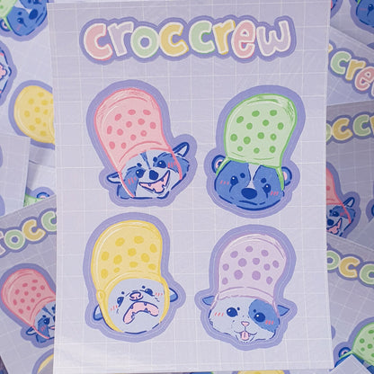 Croc Crew Sticker Sheet Featuring An Opossum, Skunk, Raccoon and Cat Wearing Crocs As Hats - Koodle